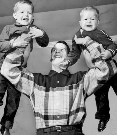 Gordie Howe lifts his two future teammates, sons  Marty (left) and Mark (right) in 1957.