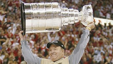 Head coach Scotty Bowman hoists the Stanley Cup trophy after the Wings won it all in 2002. He announced his retirement moments later.