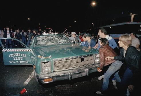 Rioters outside of Tiger Stadium destroy a Checker Cab near the intersection of Michigan & Trumbull the night the Detroit Tigers won the 1984 World Series.