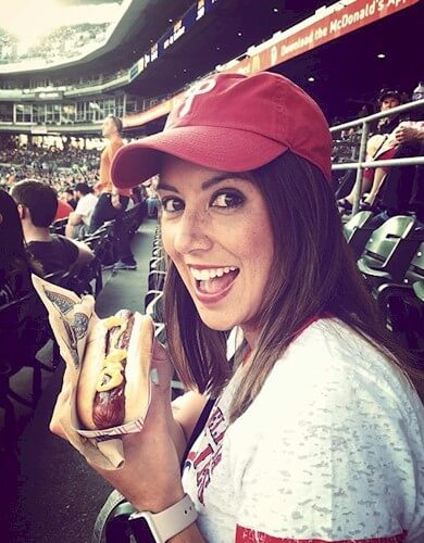 A Phillies' fan enjoys a hot dog while watching her team play the Tig