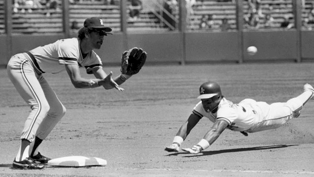 Playing third base, Enos Cabell takes a throw as Oakland's Rickey Hend